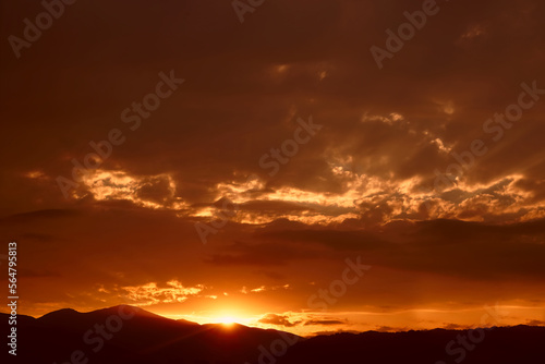 A bright colorful sunset sky over the black silhouettes of the mountains. Dark sunset sky with bright colors over a mountain. Scenic View Of Silhouette Mountains Against Sky During Sunset