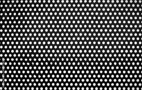 A perforated metal grunge background. circular perforated steel sheet is painted to prevent rust in gray