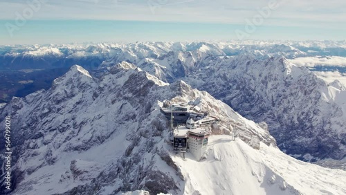 aerial of a building on a snowcapped summit of a glacier in the alps