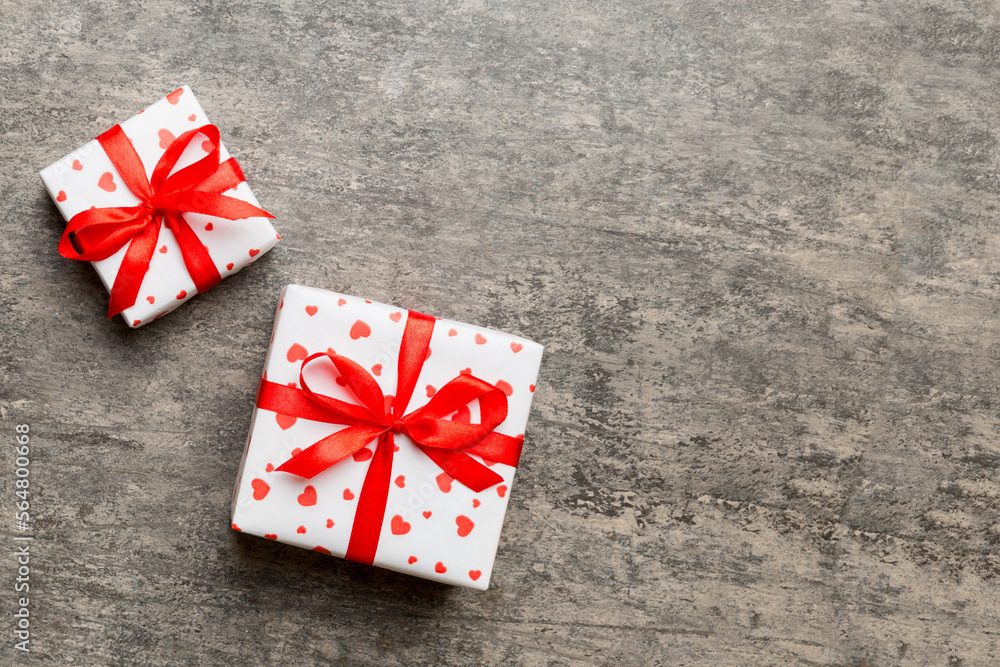 Valentine day composition: red gift box with bow and heart. Christmas present. View from above. Space for text. Holday greeting card Valentine day composition: red gift box with bow and heart. Christmas present. View from above. Space for text. Holday greeting card