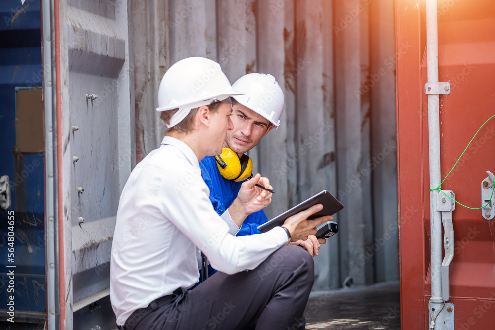 Businessman and engineer or Foreman checking the container to prepare the delivery to the customer. Businessman and engineer or Foreman checking the container to prepare the delivery to the customer.