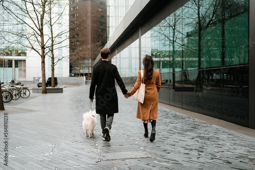 A couple walks away with their dog photo