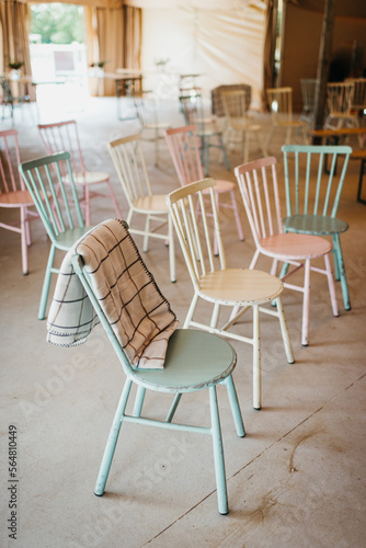 Pastel chairs lined up in a tent photo