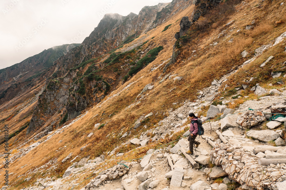 Hiker standing on mountain slope Hiker standing on mountain slope