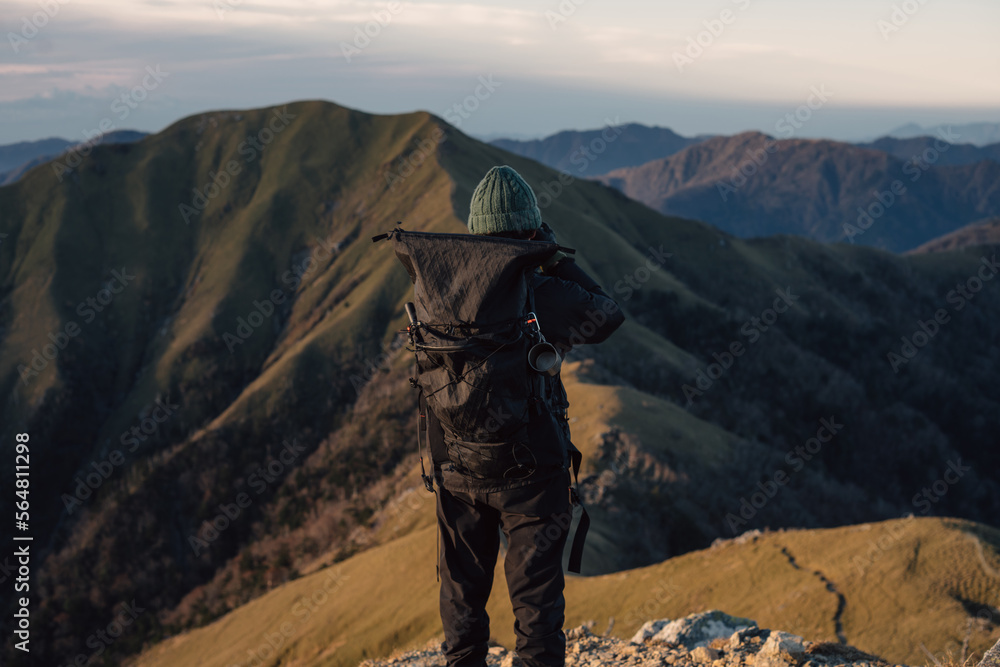 Unrecognizable hiker standing on top of mountain Unrecognizable hiker standing on top of mountain