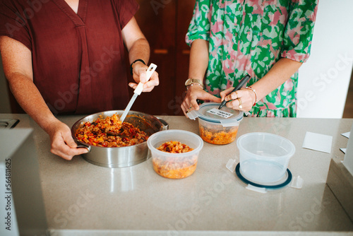 Mother and daughter prepping food in the kitchen photo