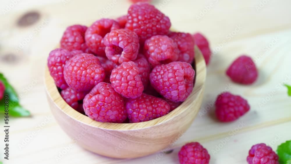Top view Rotate Red Raspberry with leaves in wooden bowl on Wooden background. Top view Rotate Red Raspberry with leaves in wooden bowl on Wooden background.