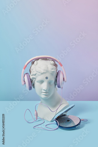 Antique bust in headphones with CD player. photo