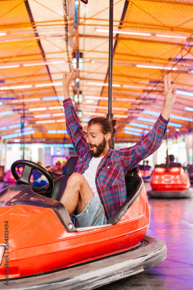 Man in bumper car gesturing V sign Man in bumper car gesturing V sign