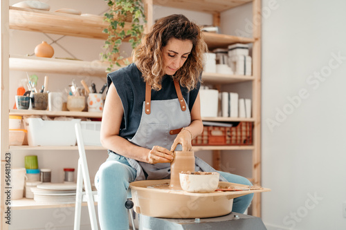 Craftswoman wetting clay vase