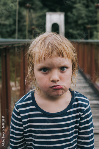 A kid posing on a wooden brodge photo