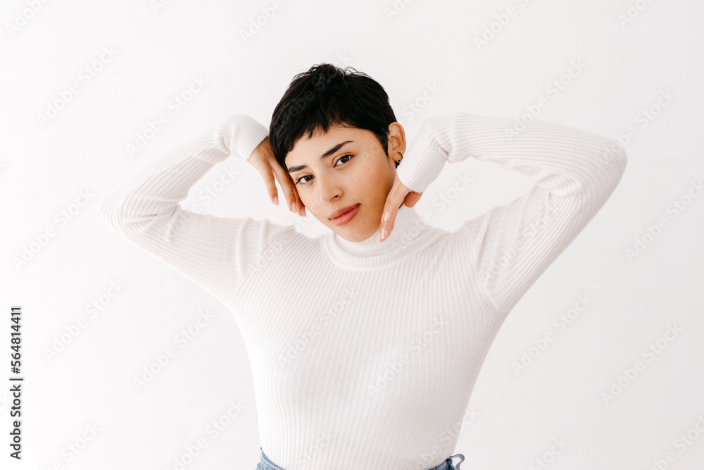 Hispanic woman touching face with raised arms Hispanic woman touching face with raised arms