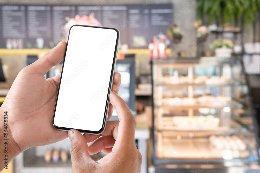 Close up view of man hand holding smart phone with blurred coffee shop on background. Close up view of man hand holding smart phone with blurred coffee shop on background.