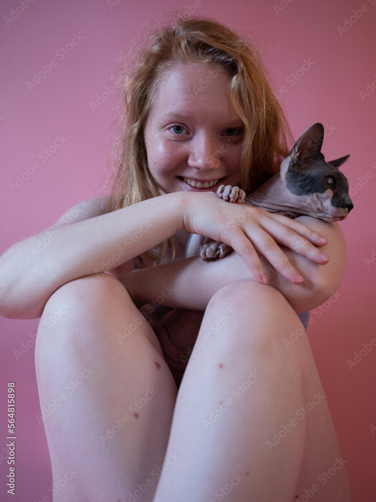 Portrait of a woman laughing hugging a bold cat Portrait of a woman laughing hugging a bold cat