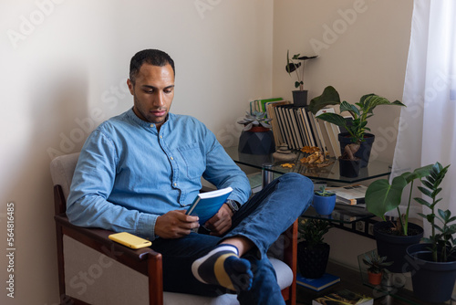 portrait of a man in a chair with a book photo