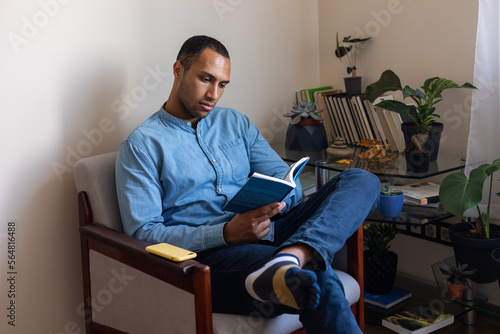 portrait of a man with a book in a chair photo