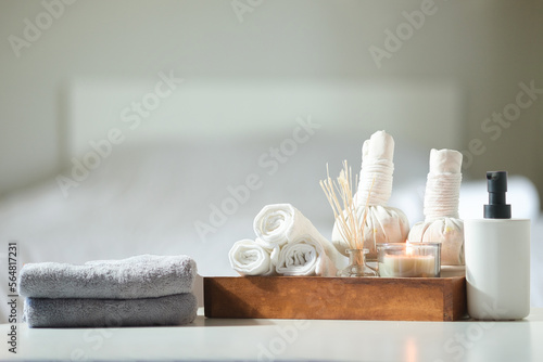 Spa treatment concept. Towels, massage oil, spa herbal compress balls and burning candles on table with copy space.