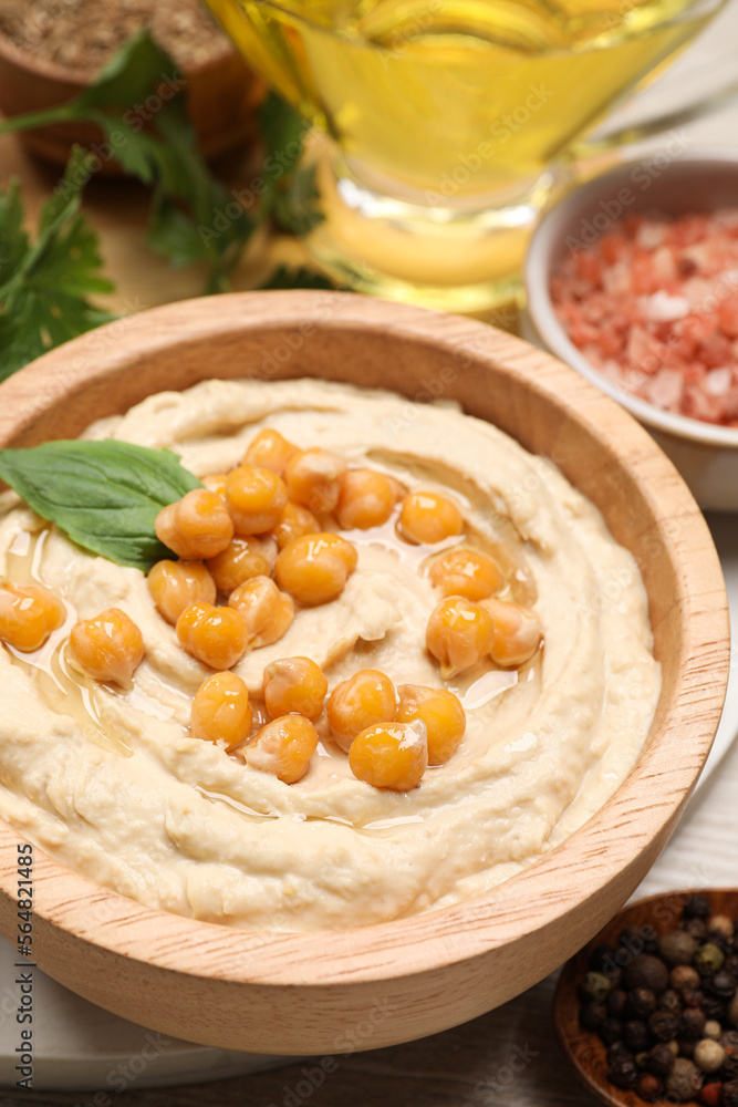 Bowl with delicious hummus and chickpeas on table, closeup Bowl with delicious hummus and chickpeas on table, closeup
