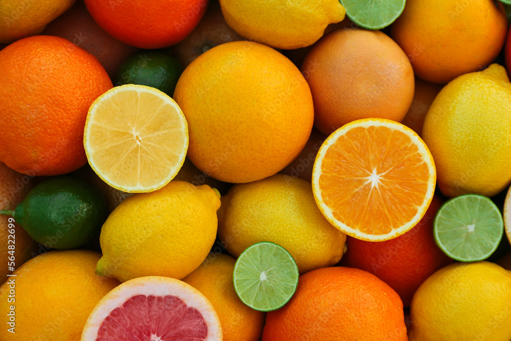 Many different whole and cut citrus fruits as background, top view Many different whole and cut citrus fruits as background, top view