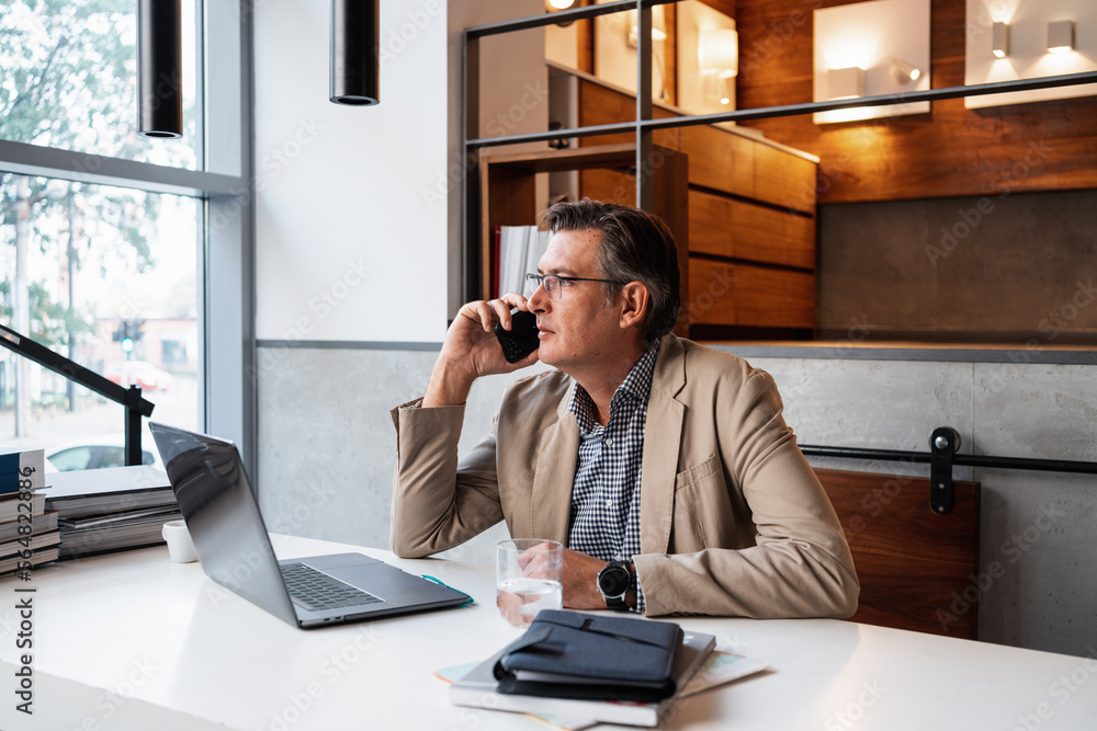 Businessman Talking On The Phone In The Workplace Businessman Talking On The Phone In The Workplace