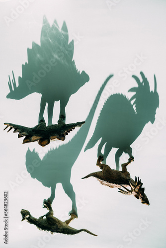 Toy figures of dinosaurs and their shadows. photo