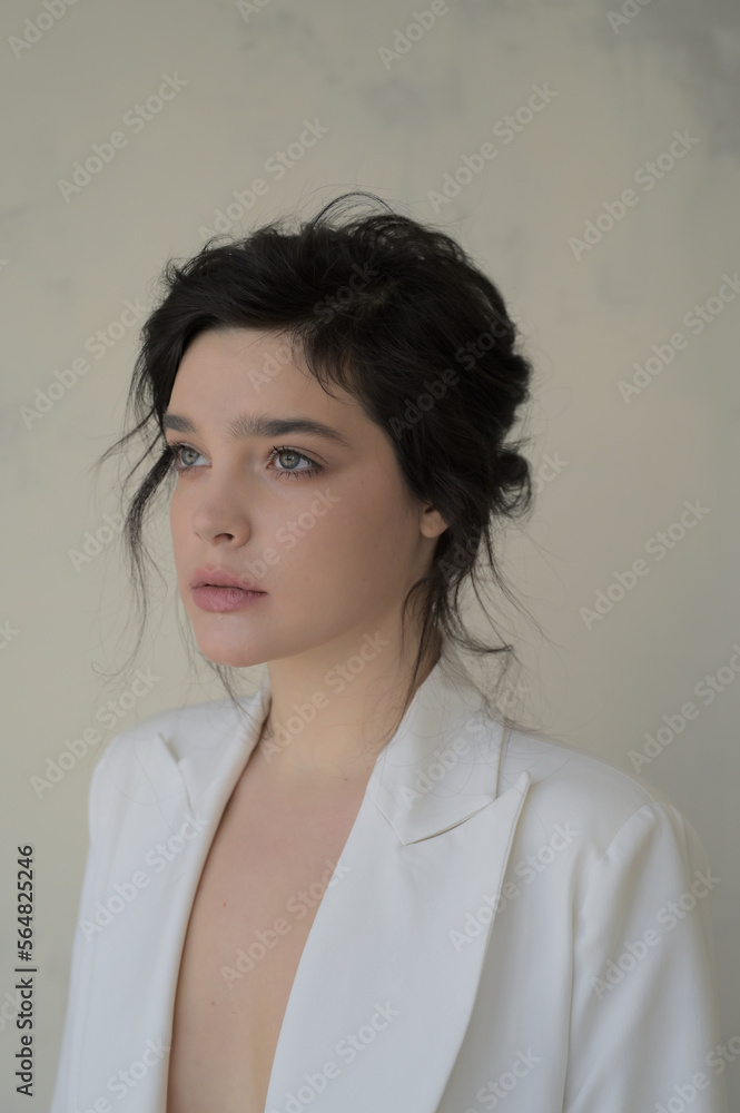 Portrait of a young beautiful brunette woman in a white suit. Portrait of a young beautiful brunette woman in a white suit.