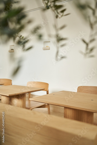 Timber tables and chairs against beige wall