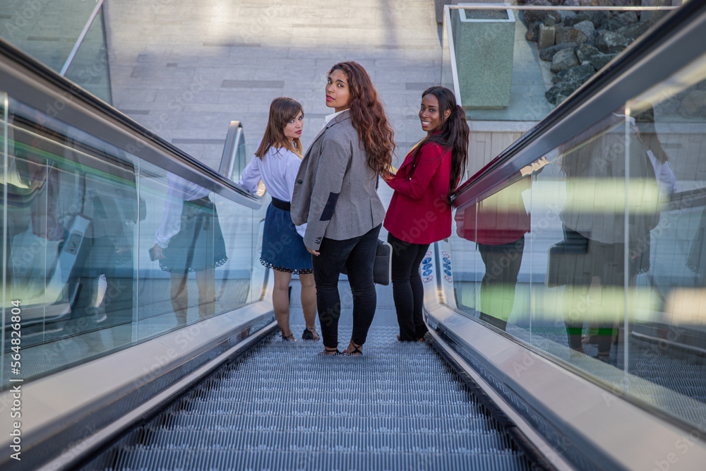 custom made wallpaper toronto digitalThree businesswomen on the escalators in the business building on their way to work.