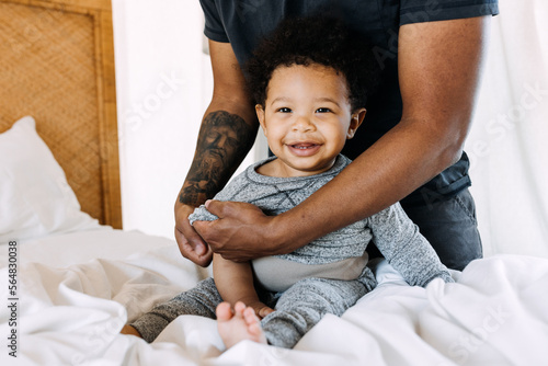 A father changing his baby's clothes