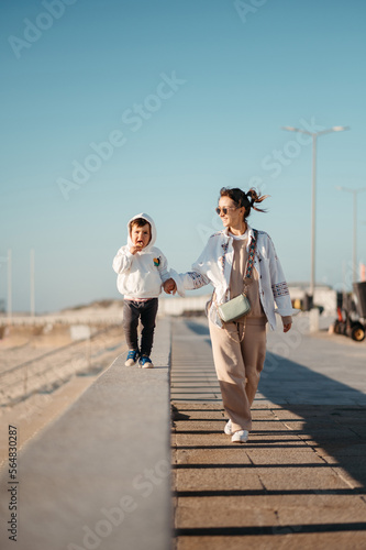 Mother stroll with son along beach. photo