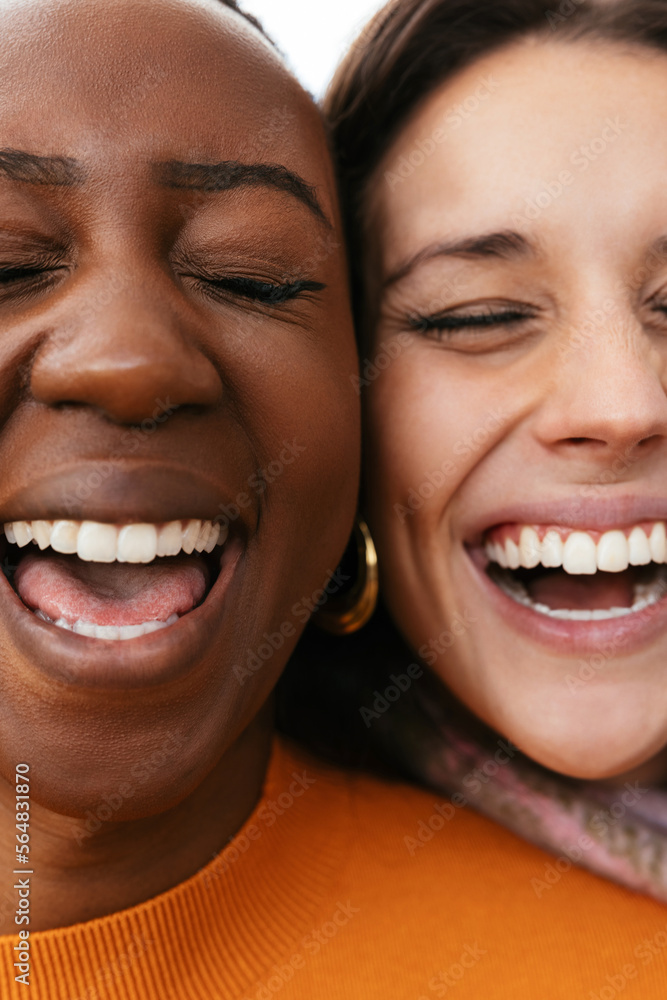 Joyful diverse women laughing with closed eyes Joyful diverse women laughing with closed eyes
