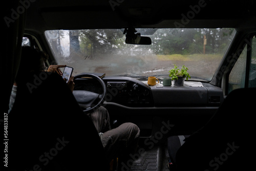 Man resting and using phone inside car 