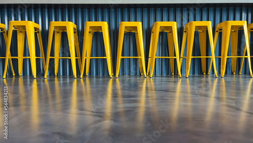 Row of bright yellow bar stools low angle at bar photo
