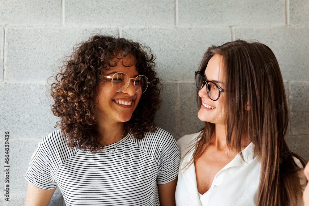 © Valentina Barreto/Stocksy - Female friends laughing looking each other