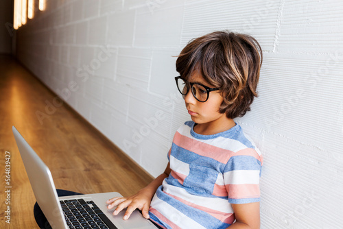 Smarty kid with laptop sitting on the floor photo