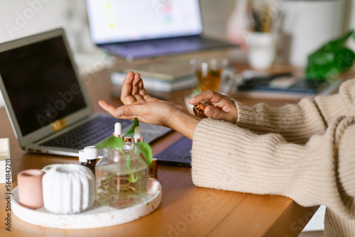 Felmale testing perfume at desk