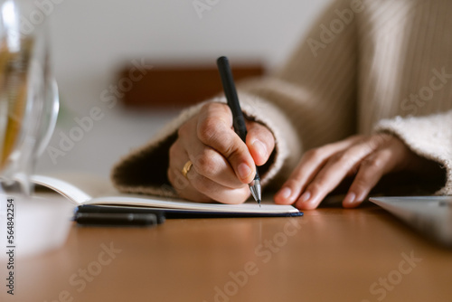 Female writing on notebook closeup photo