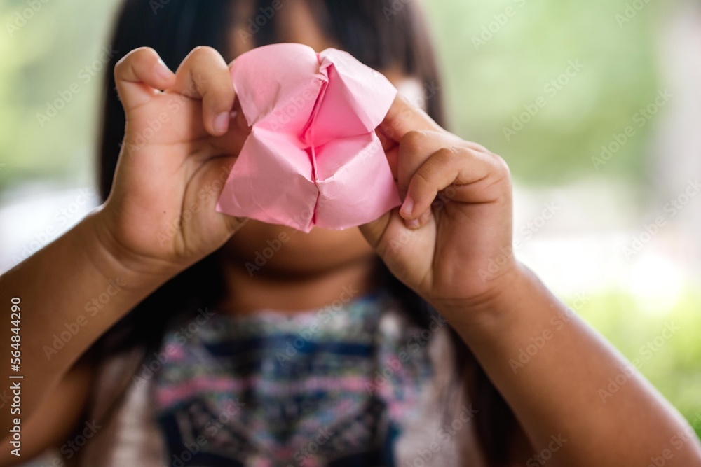 Girl holding pink folded origami paper Girl holding pink folded origami paper