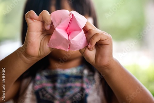 Girl holding pink folded origami paper photo