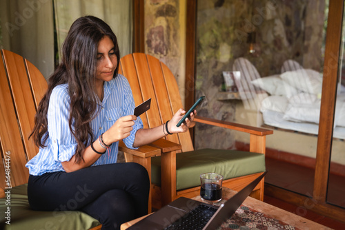 woman holding a credit card and her phone