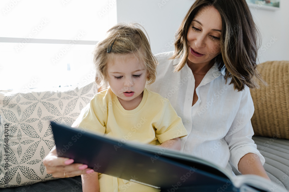Mother reading a book to her baby Mother reading a book to her baby