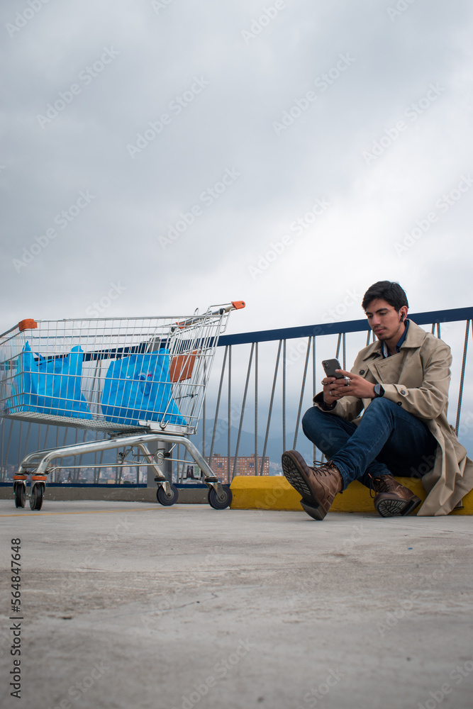 Market car and man looking his phone in a parking on cloudy day Market car and man looking his phone in a parking on cloudy day