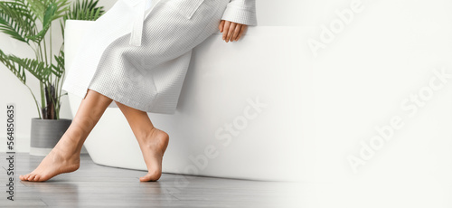 Barefoot legs of woman sitt...
