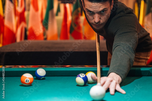 Focused sportsman playing pool in club photo