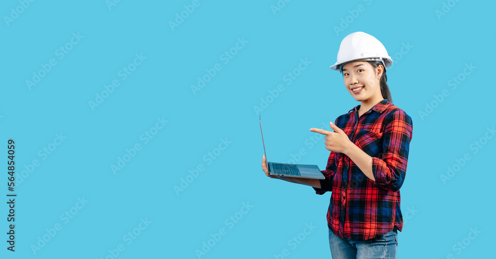 Young female engineer wearing helmet and use laptop computer Young female engineer wearing helmet and use laptop computer