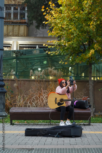Female vlogger preparing for busking in city park photo