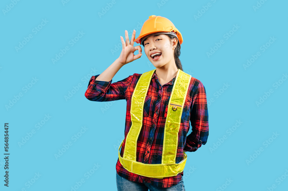 Young female engineer in helmet stand with OK sign posture