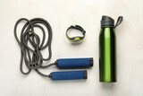 Skipping rope with smartwatch and bottle on white background