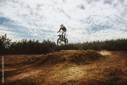 Young Man on Dirt bike jump in blue sky photo