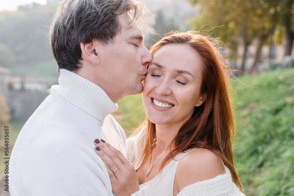 A loving couple husband and wife hugging, a man gently kisses a A loving couple husband and wife hugging, a man gently kisses a